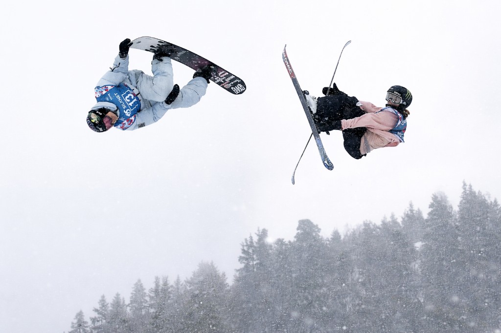 Skier and snowboarder performing aerial tricks