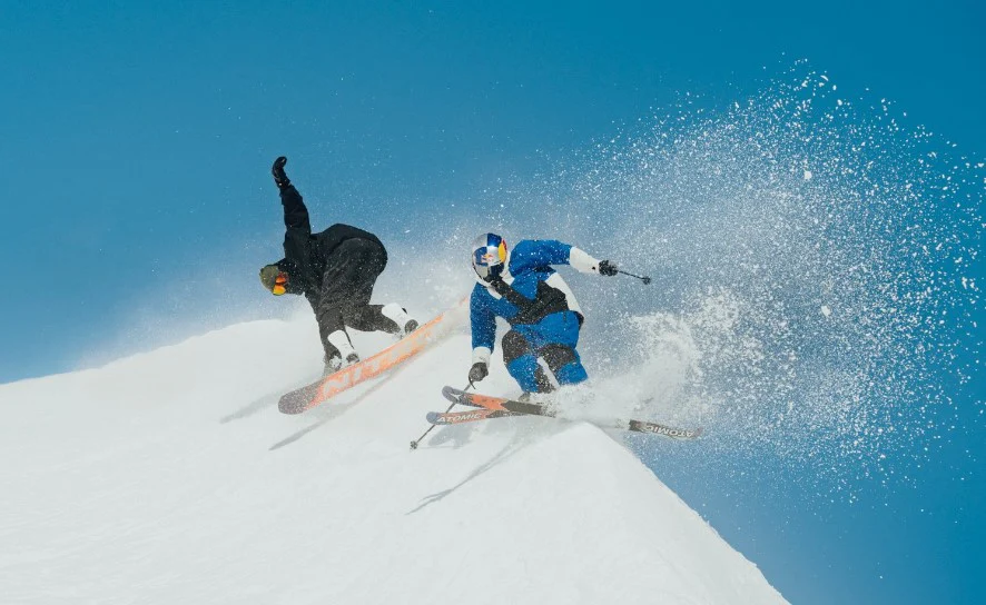 Skier and snowboarder on snowy slope